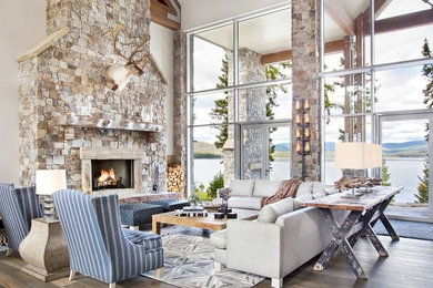 Inspiration for a large country formal open concept living room in Other with white walls, medium hardwood floors, a standard fireplace, a stone fireplace surround, no tv and brown floor.
