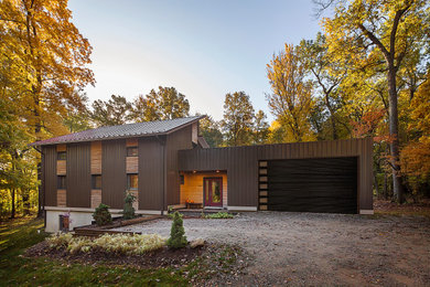 Example of a mid-sized minimalist brown two-story mixed siding house exterior design in Detroit with a shed roof, a metal roof and a red roof