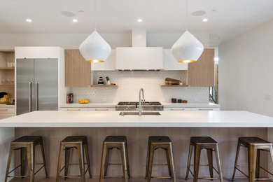 Design ideas for a contemporary eat-in kitchen in San Francisco with white splashback, stainless steel appliances and white benchtop.