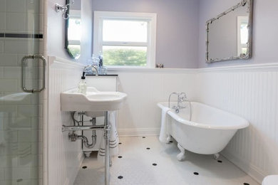 This is an example of a mid-sized traditional master bathroom in Los Angeles with a claw-foot tub, an alcove shower, white tile, subway tile, porcelain floors, a wall-mount sink, solid surface benchtops, white floor, a hinged shower door, furniture-like cabinets, white cabinets, a two-piece toilet and grey walls.