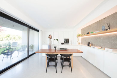 Foto di una sala da pranzo minimalista di medie dimensioni con pavimento in cemento e pavimento grigio