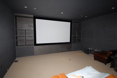 Imagen de cine en casa cerrado bohemio pequeño con paredes negras, moqueta y pantalla de proyección