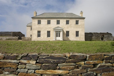 Photo of a large traditional two-storey beige exterior in Devon with stone veneer and a hip roof.