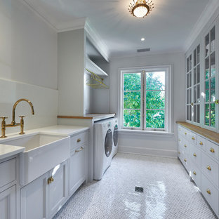 ニューヨークのトランジショナルスタイルのおしゃれなランドリールーム (ガラスカウンター、大理石の床) の写真