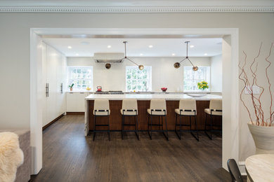 Example of a large minimalist l-shaped medium tone wood floor and brown floor eat-in kitchen design in Philadelphia with an undermount sink, flat-panel cabinets, white cabinets, quartzite countertops, white backsplash, ceramic backsplash, paneled appliances, an island and white countertops