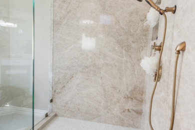 Photo of a medium sized traditional ensuite bathroom in Dallas with recessed-panel cabinets, white cabinets, a freestanding bath, a corner shower, a one-piece toilet, beige tiles, stone slabs, beige walls, porcelain flooring, a submerged sink, quartz worktops, beige floors, a hinged door, beige worktops, an enclosed toilet, double sinks and a built in vanity unit.