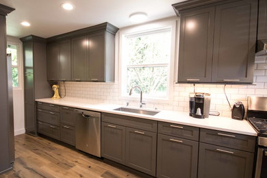 Eat-in kitchen - mid-sized contemporary galley laminate floor eat-in kitchen idea in Portland with an undermount sink, shaker cabinets, gray cabinets, quartz countertops, white backsplash, ceramic backsplash, stainless steel appliances and no island