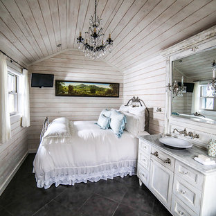 Photo of a small shabby-chic style master bedroom in Charlotte with white walls and porcelain floors.