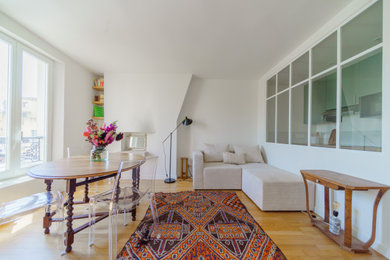 Aménagement d'une salle de séjour contemporaine de taille moyenne avec un mur blanc, parquet clair, une cheminée standard et un manteau de cheminée en plâtre.