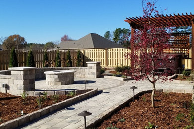 Mid-sized elegant backyard concrete paver patio photo in Other with a fire pit and a pergola