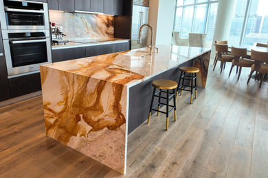 Minimalist kitchen photo in Austin with quartzite countertops, orange backsplash, an island and orange countertops