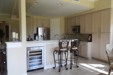 Mid-sized transitional l-shaped porcelain tile and beige floor eat-in kitchen photo in Miami with an undermount sink, shaker cabinets, beige cabinets, granite countertops, stone slab backsplash, stainless steel appliances and no island