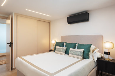 Imagen de dormitorio principal y beige y blanco minimalista pequeño con paredes blancas y suelo de baldosas de cerámica