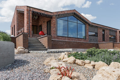 Diseño de fachada de casa marrón y marrón contemporánea de una planta con revestimientos combinados, tejado a dos aguas y tejado de teja de madera