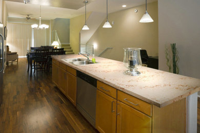 Example of a mid-sized transitional single-wall dark wood floor and brown floor eat-in kitchen design in Los Angeles with stainless steel appliances, an island, shaker cabinets, medium tone wood cabinets, quartz countertops and beige countertops