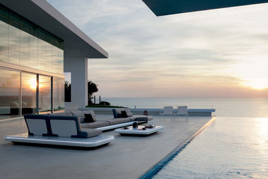 Idee per un patio o portico design dietro casa con pavimentazioni in cemento e nessuna copertura