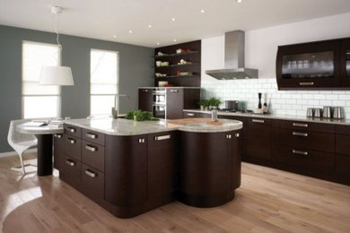 Example of a large classic single-wall medium tone wood floor and brown floor open concept kitchen design in San Francisco with an undermount sink, flat-panel cabinets, brown cabinets, granite countertops, white backsplash, subway tile backsplash, stainless steel appliances and an island
