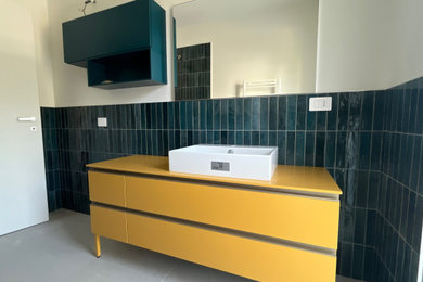 Esempio di una piccola stanza da bagno con doccia minimal con consolle stile comò, doccia a filo pavimento, WC sospeso, piastrelle verdi, piastrelle in ceramica, pareti bianche, pavimento in gres porcellanato, lavabo a bacinella, top in superficie solida, pavimento grigio, porta doccia a battente, top giallo, un lavabo e mobile bagno freestanding