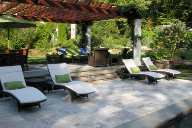 Patio fountain - large traditional backyard stone patio fountain idea in New York with a pergola