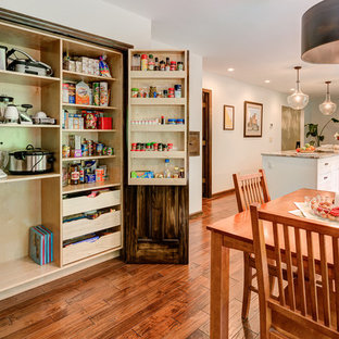 Mid-sized transitional kitchen pantry designs - Inspiration for a mid-sized transitional galley medium tone wood floor kitchen pantry remodel in Columbus with a double-bowl sink, shaker cabinets, white cabinets, granite countertops, white backsplash, subway tile backsplash, stainless steel appliances and an island