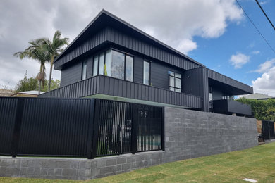Großes, Zweistöckiges Modernes Einfamilienhaus mit Metallfassade, schwarzer Fassadenfarbe und Flachdach in Brisbane
