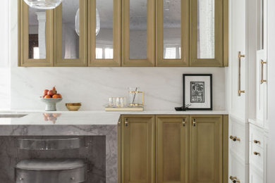 Example of a mid-sized transitional u-shaped medium tone wood floor and brown floor open concept kitchen design in Boston with a farmhouse sink, recessed-panel cabinets, white cabinets, marble countertops, white backsplash, marble backsplash, stainless steel appliances, an island and white countertops