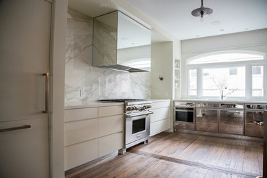 Open concept kitchen photo in Toronto with white cabinets, white backsplash, marble backsplash and stainless steel appliances
