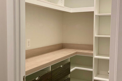 Medium sized country l-shaped kitchen pantry in DC Metro with flat-panel cabinets, dark wood cabinets, laminate countertops and brown worktops.