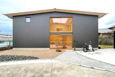 Imagen de fachada de casa gris y gris de tamaño medio de dos plantas con revestimiento de metal, tejado a dos aguas y tejado de metal