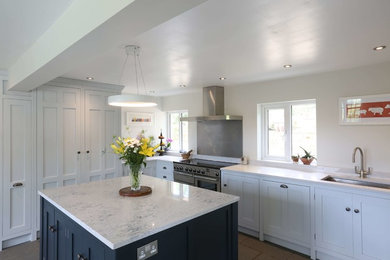 This is an example of a country kitchen in Other with grey cabinets and with island.