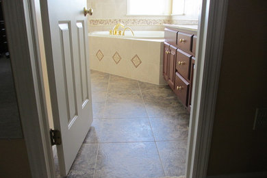 Bathroom - mid-sized traditional master beige tile and porcelain tile linoleum floor bathroom idea in Other with raised-panel cabinets, medium tone wood cabinets, granite countertops, an integrated sink, a one-piece toilet and beige walls