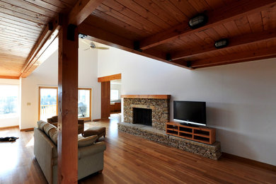 Large mountain style loft-style medium tone wood floor family room photo in Phoenix with white walls, a standard fireplace, a stone fireplace and a tv stand