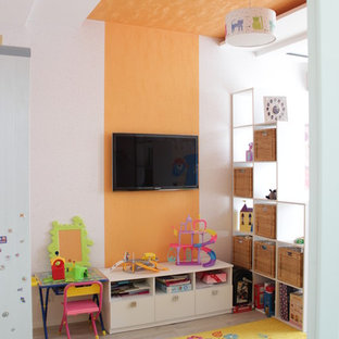 Idée de décoration pour une chambre d'enfant de 1 à 3 ans design de taille moyenne avec un mur orange, sol en stratifié et un sol beige.