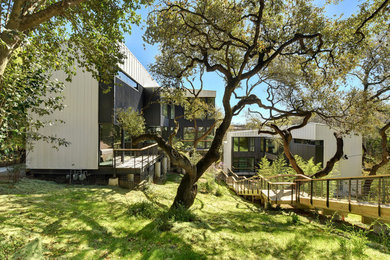 This is an example of a contemporary two-storey white house exterior in Austin with a shed roof.
