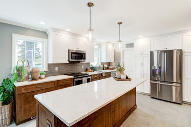 Example of a large u-shaped vinyl floor and gray floor kitchen design in Other with an undermount sink, recessed-panel cabinets, dark wood cabinets, quartz countertops, gray backsplash, ceramic backsplash, stainless steel appliances, an island and white countertops
