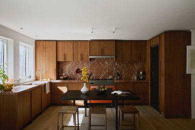 Photo of a large contemporary u-shaped open plan kitchen with a built-in sink, flat-panel cabinets, brown cabinets, marble worktops, red splashback, marble splashback, coloured appliances, light hardwood flooring, beige floors, red worktops and feature lighting.