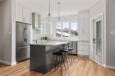 Example of a trendy kitchen design in Calgary with shaker cabinets, white cabinets and quartz countertops