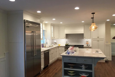 Inspiration for a mid-sized l-shaped dark wood floor enclosed kitchen remodel in Denver with a drop-in sink, recessed-panel cabinets, white cabinets, white backsplash, ceramic backsplash, stainless steel appliances and an island
