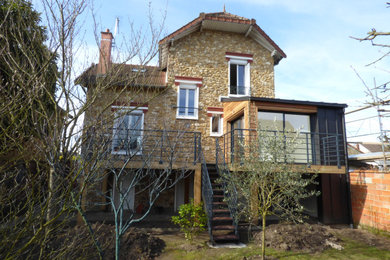Cette image montre une petite façade de maison design en bois et bardage à clin à un étage avec un toit noir.