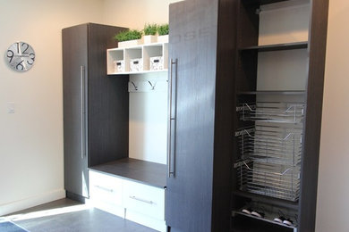 Inspiration for a mid-sized transitional mudroom in Calgary with white walls, dark hardwood floors and black floor.