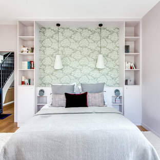 Contemporary bedroom in Paris with pink walls and medium hardwood floors.