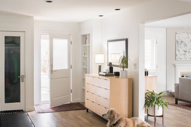 Large trendy light wood floor and brown floor entryway photo in Denver with white walls and a white front door