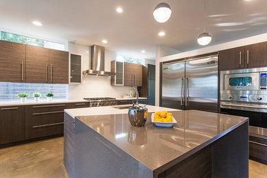 This is an example of a mid-sized contemporary u-shaped eat-in kitchen in Seattle with flat-panel cabinets, quartz benchtops, white splashback, stainless steel appliances, with island, a drop-in sink, medium wood cabinets, subway tile splashback and porcelain floors.