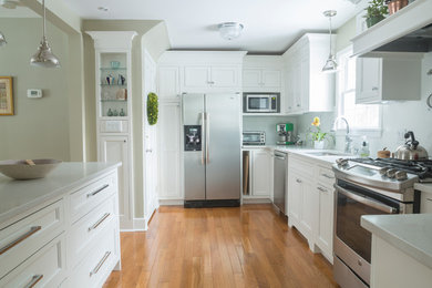 Eat-in kitchen - small traditional galley light wood floor eat-in kitchen idea in New York with white cabinets, quartz countertops, white backsplash, stainless steel appliances, a peninsula, an undermount sink and porcelain backsplash