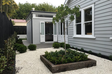 This is an example of a small country side yard garden in Auckland with a container garden and gravel.