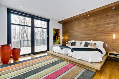 Photo of a contemporary guest bedroom in Montreal with white walls, medium hardwood floors and no fireplace.