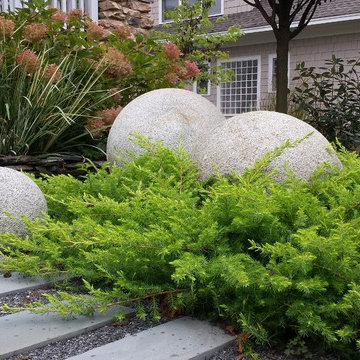 'All Gold' shore junipers with granite spheres.