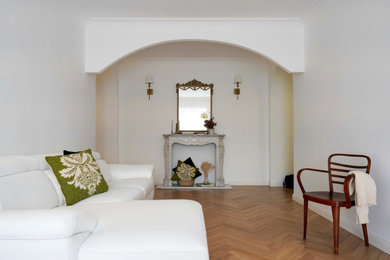 Foto di un soggiorno contemporaneo con pareti bianche, parquet chiaro, camino classico e cornice del camino in pietra