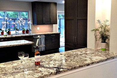 Large transitional u-shaped marble floor open concept kitchen photo in Houston with an undermount sink, shaker cabinets, dark wood cabinets, granite countertops, beige backsplash, ceramic backsplash, stainless steel appliances and an island
