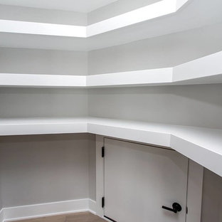 На фото: угловая кухня среднего размера в современном стиле с кладовкой, врезной раковиной, фасадами в стиле шейкер, белыми фасадами, столешницей из гранита, серым фартуком, фартуком из металлической плитки, техникой из нержавеющей стали, светлым паркетным полом, островом, коричневым полом и белой столешницей с